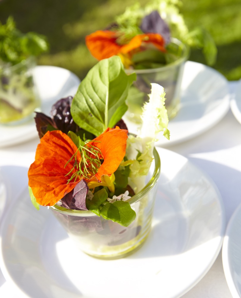 Small Cups Of Salad Appetizers With Edible Flower Garnish