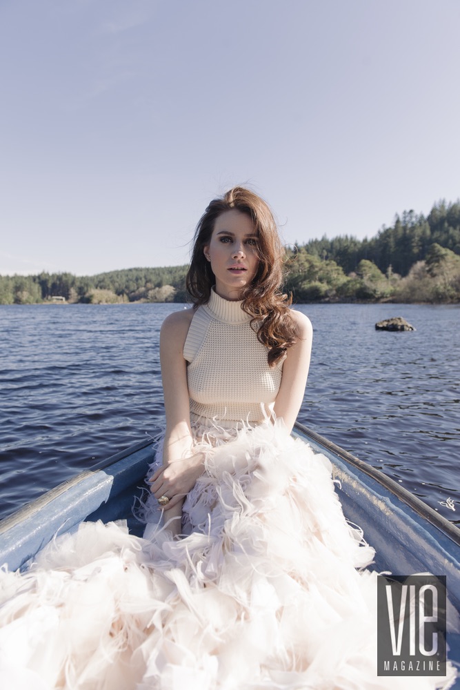 Faye Dinsmore in a boat on the water near Ballynahinch Castle Christian Siriano gown