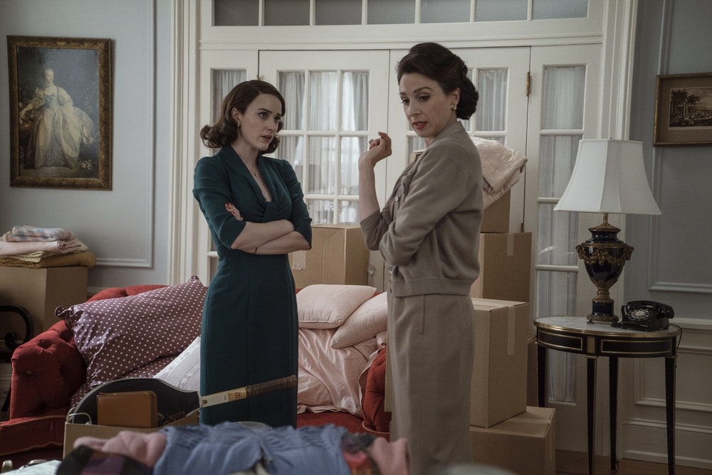 Rachel Brosnahan and Marin Hinkle in Season 1 of The Marvelous Mrs. Maisel talking in the living room about all of her belongings after she moved back into her parents house