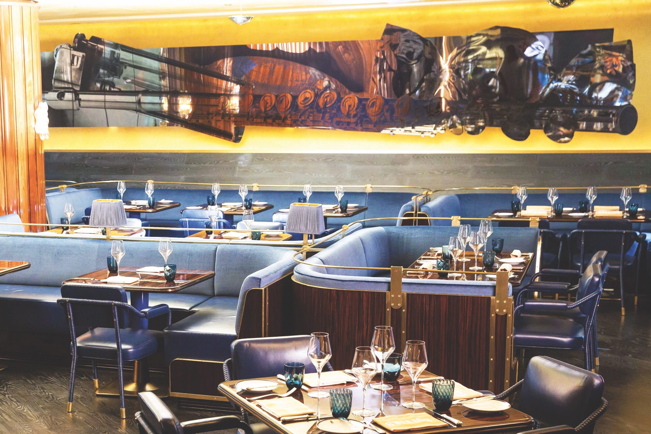 Bullion restaurant has a beautiful interior with large wall art and plush blue, seats.