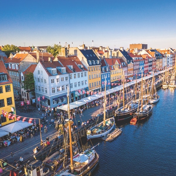 Beautiful historical city center. Nyhavn New Harbour canal and entertainment district in Copenhagen, Denmark. The canal harbours many historical wooden ships. Aerial view from the top.