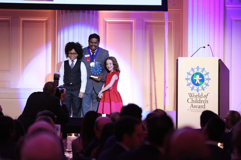 Honoree Iyyappan Subramaniyan accepts an award on stage during the World of Children Awards Ceremony