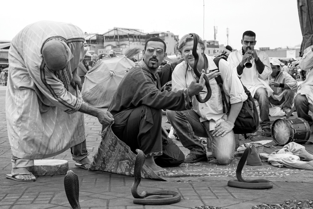Street performer placing deadly snakes on tourist head in Morocco
