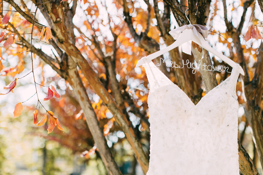 Wedding dress hanging in fall leaves
