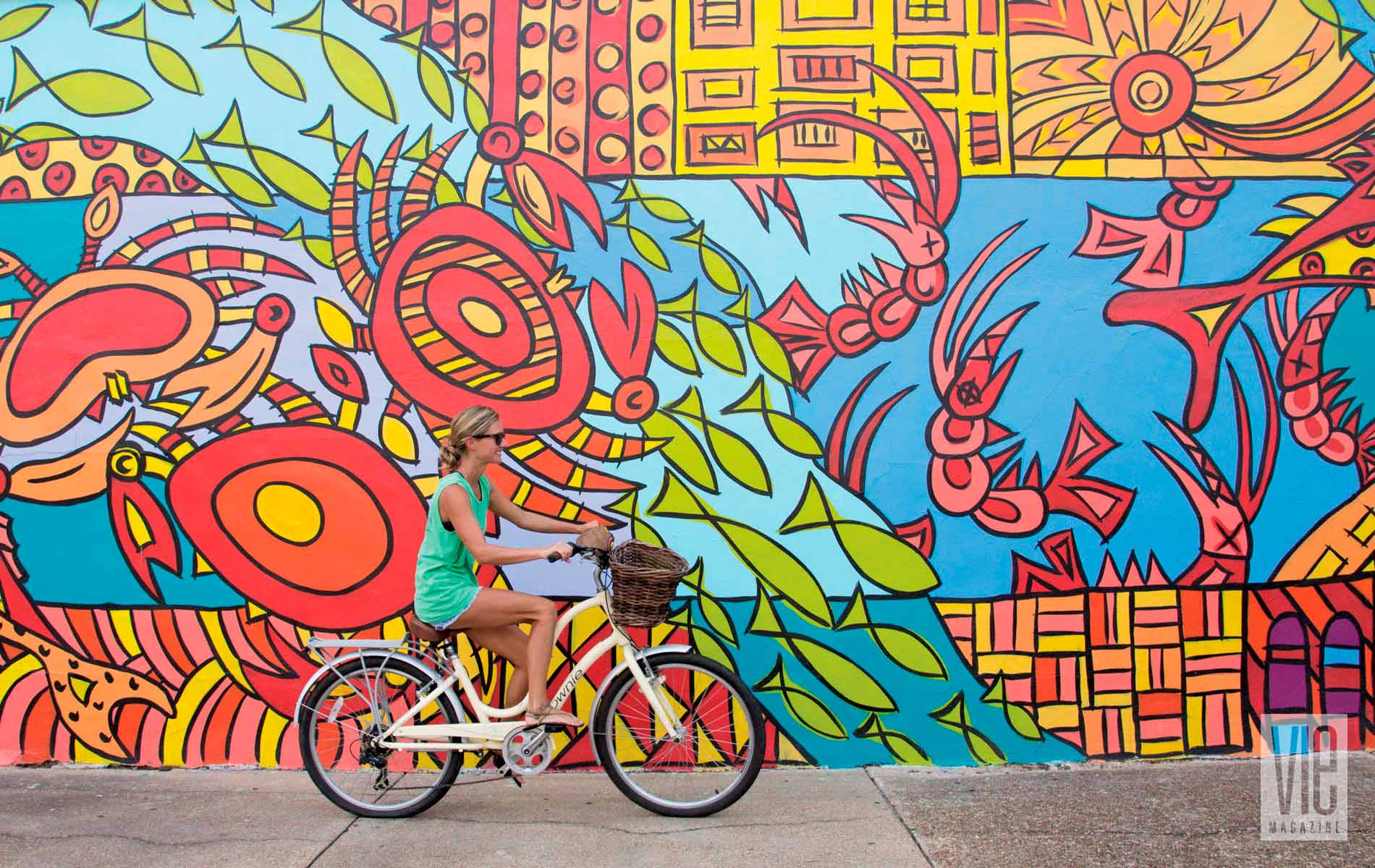 Chelsey Allegri rides her bike downtown past Aboriginal Sealife, a mural painted by Ameri'ca Jones.
