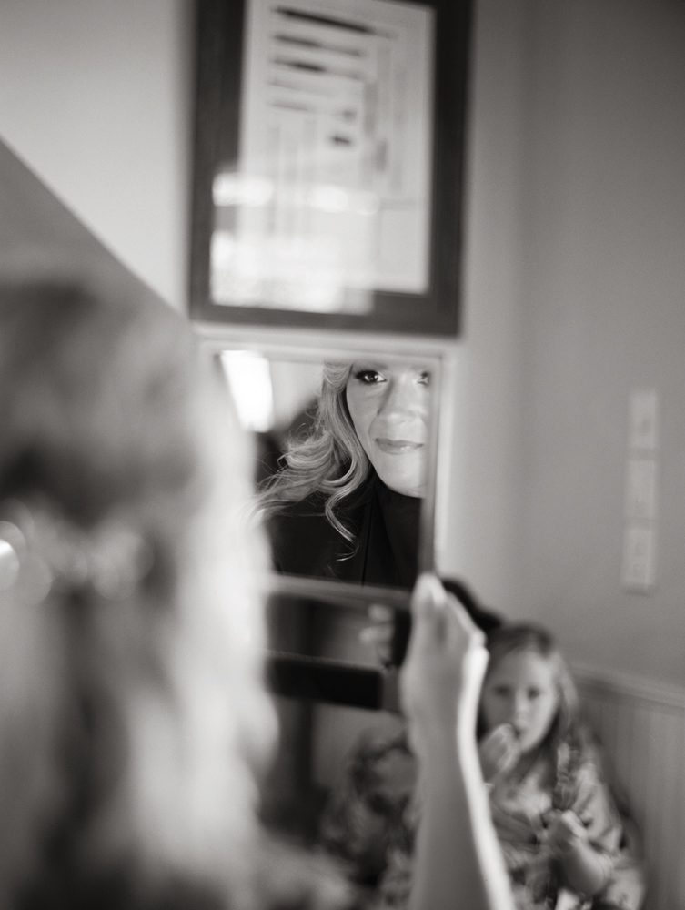 Bride, Jennifer Goff, checking her makeup in the mirror