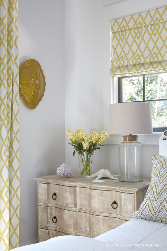 Bedside table with yellow flowers and curtains