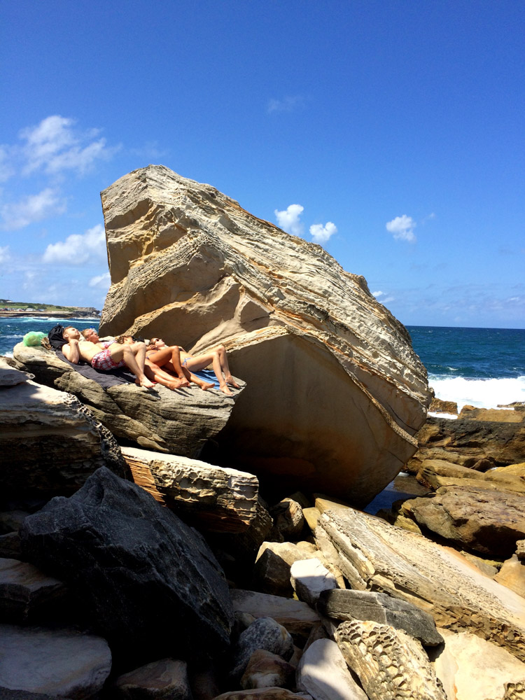 Sunbathing on the rocks at the Coogee Beach bogey hole, Sydney, Australia