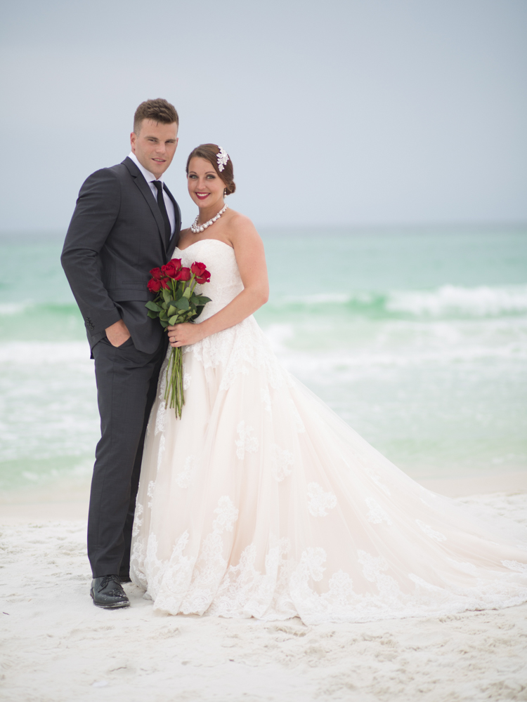 Wedding Event Specialists bride and groom posing on beach. Photo by Palafox Street Weddings