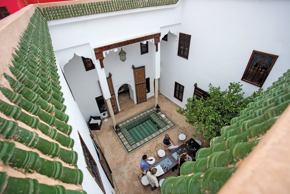Open room with pool and people dining in Morocco