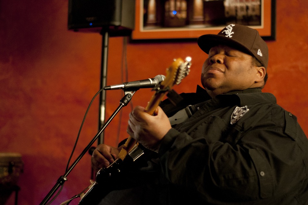 Derwin "Big D" Perkins, guitarist, often closes his eyes while performing so as to connect with each musical note.