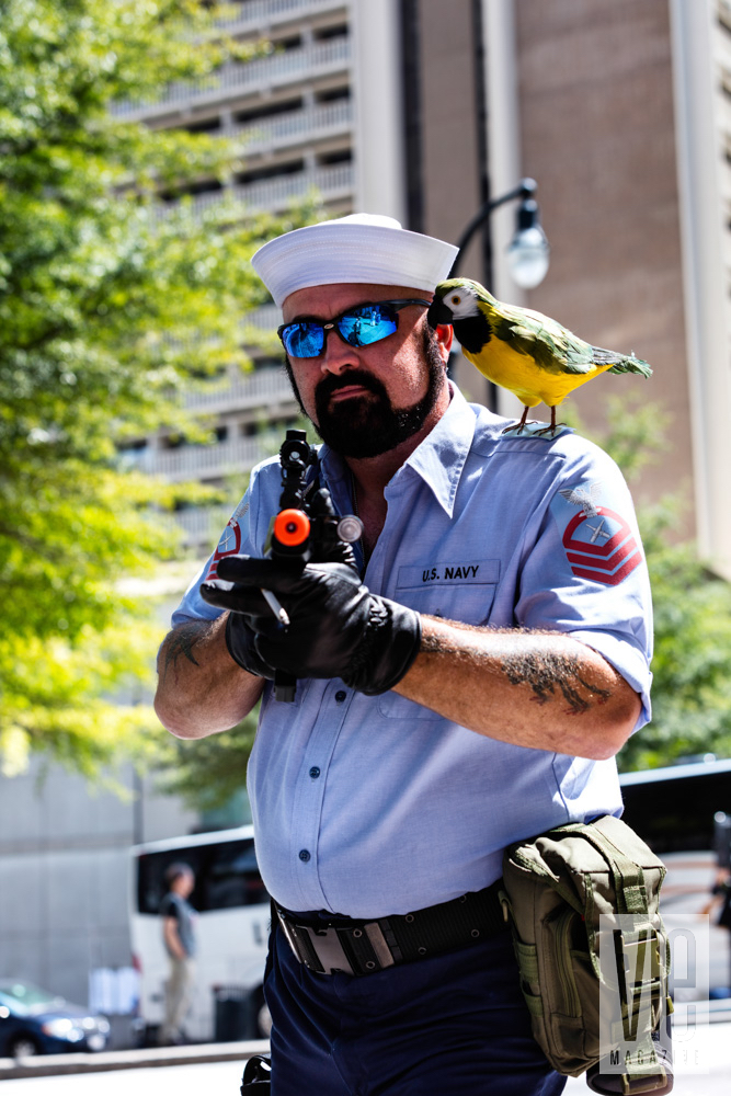 Guy holding a gun with a parrot costume dragon con