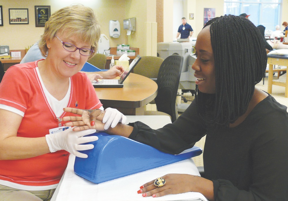 Heidi Richardson, OTR/L, CHT, works with Qwana Gable for treatment after a burn injury