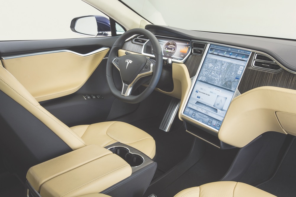 The sleek and luxurious interior of the Model S features supple leather, exotic wood, and high-tech instrumentation, including an oversized touch screen interface in the center console