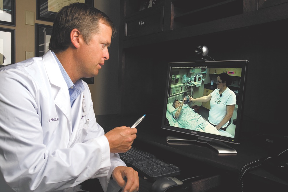 Dr. Terry Neill conducts a stroke consult on a patient in Miramar Beach from his office in Pensacola via Sacred Heart's telemedicine system. 