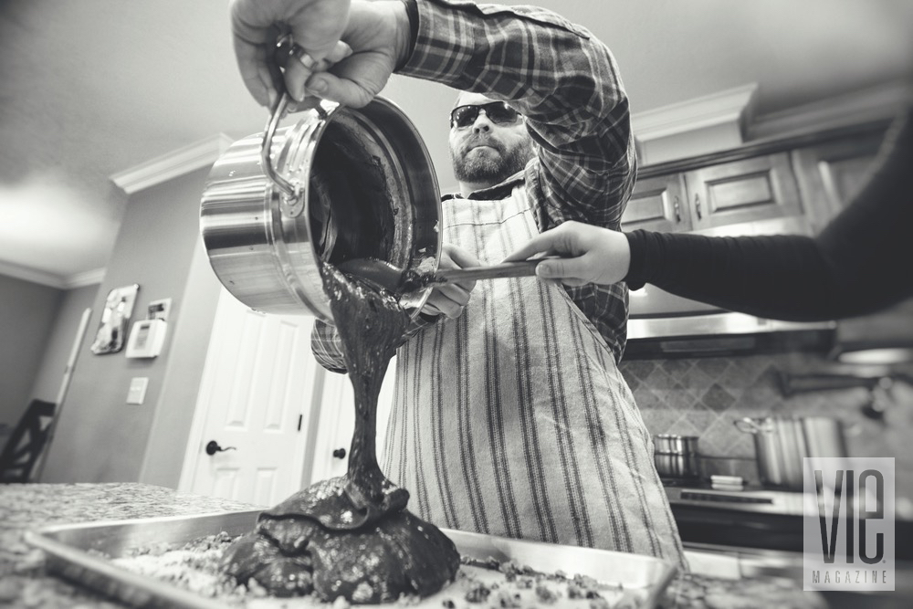 Aaron Hale Pouring Fudge Batter Into A Baking Pan With McKayla Tracy Spooning Out Mixture