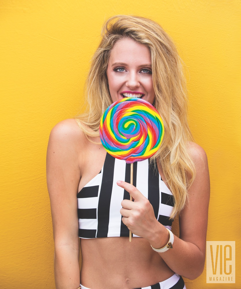 Model Emme Martin in Cayce Collins swimwear with a colorful lollipop