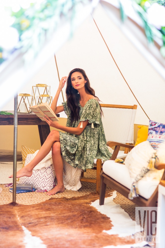 Brunette model inside the tent reading a book fancy camping glamping outdoors