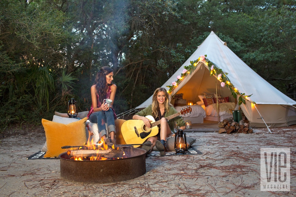 Girls drinking coffee and playing guitar by the fire Fancy Camps Glamping