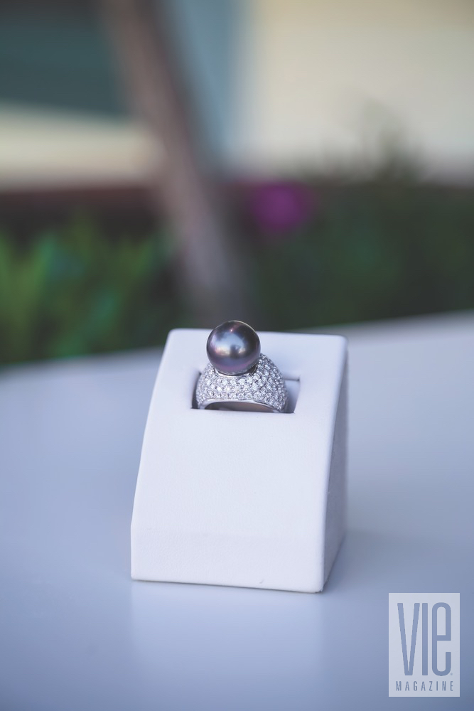 A Big Black Pearl Cocktail Ring Surrounded By A Setting Of Pave Diamonds Resting On A Ring Case