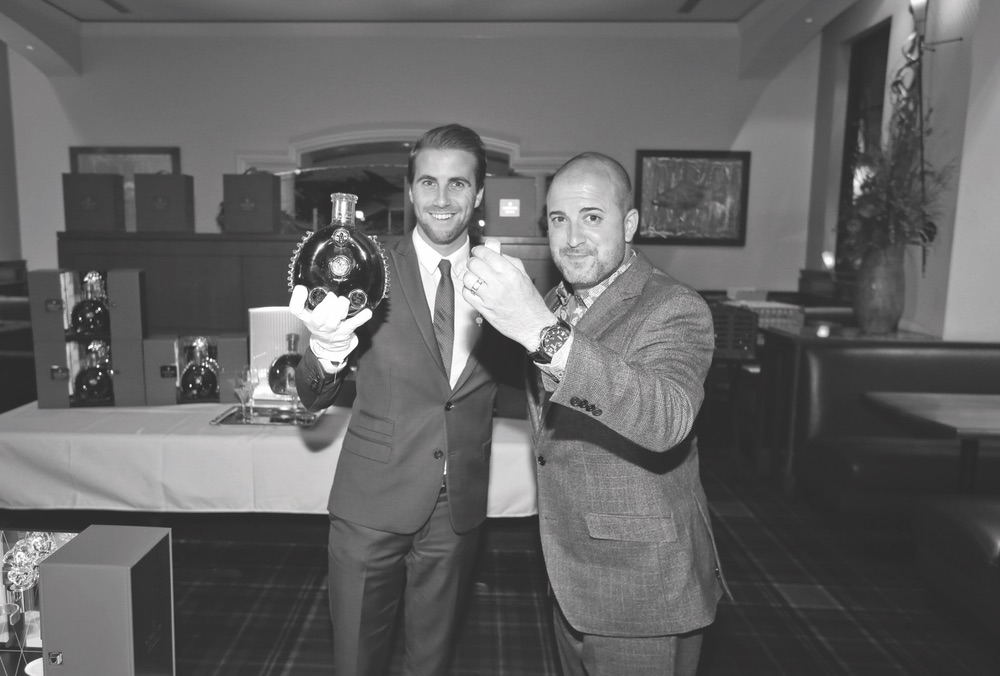 Two men holding up Louis XIII decanter Capt Andersons Celebration The Sophisticate Issue 2016