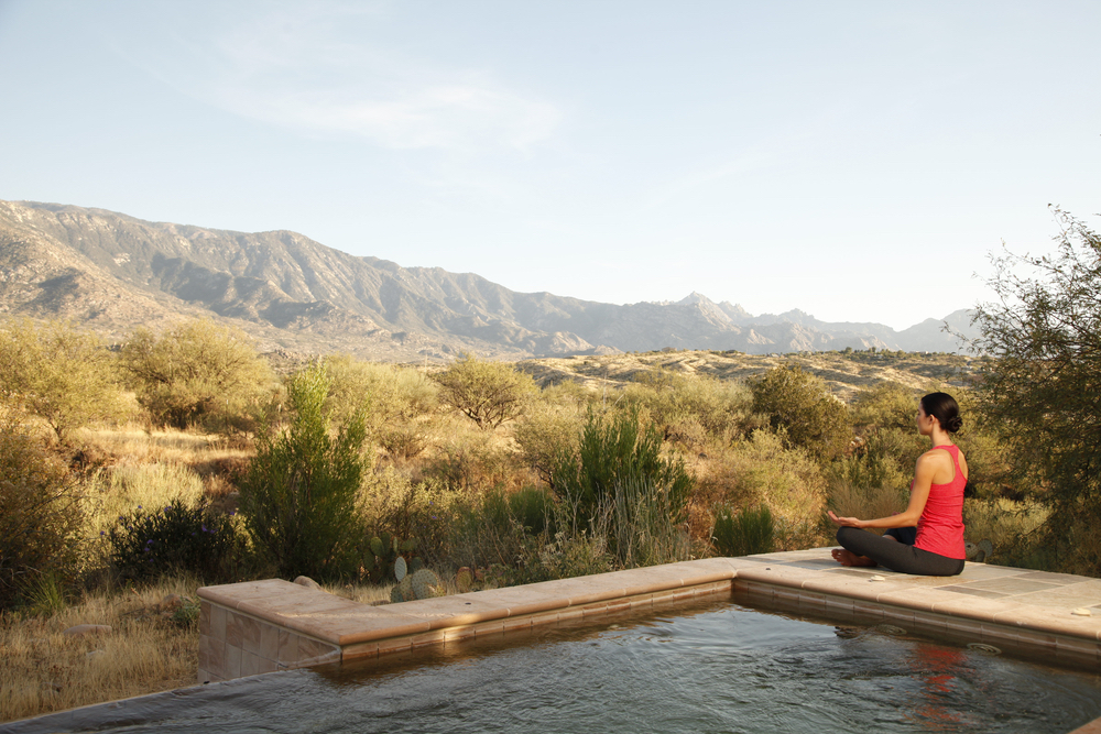 Woman meditating poolside at Miraval Resort in Tuscon, Arizona