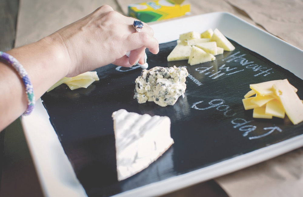 labeling cheese with chalk on cheese platter