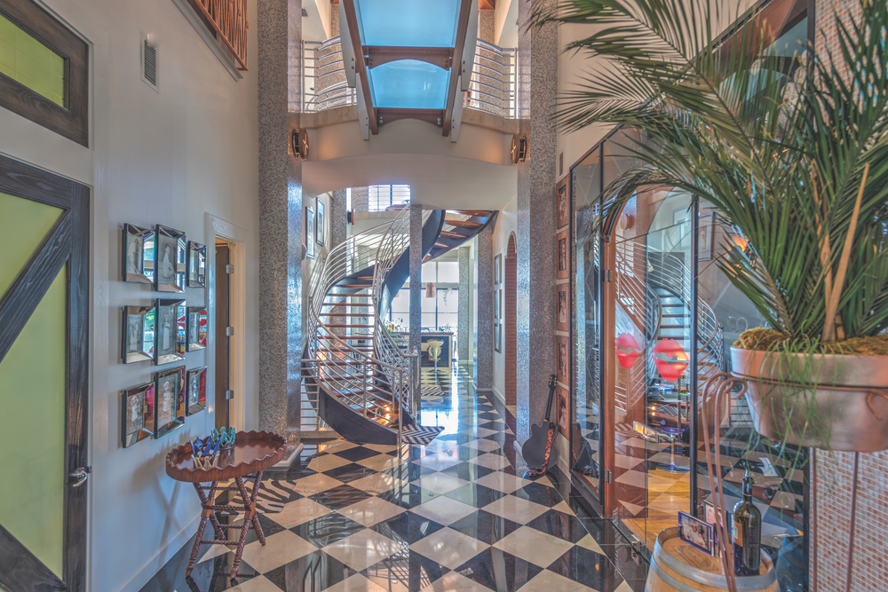 Dr. Bill and Pam Burden home preview. This amazing winding staircase of hardwood treads, stainless steel balustrades, and laminated wood carriage is a spectacular centerpiece to this light and airy two-story gallery.