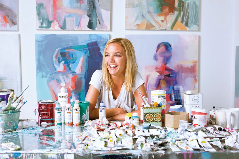 Teil Duncan sitting with her paints and tools, photo by Minette Hand