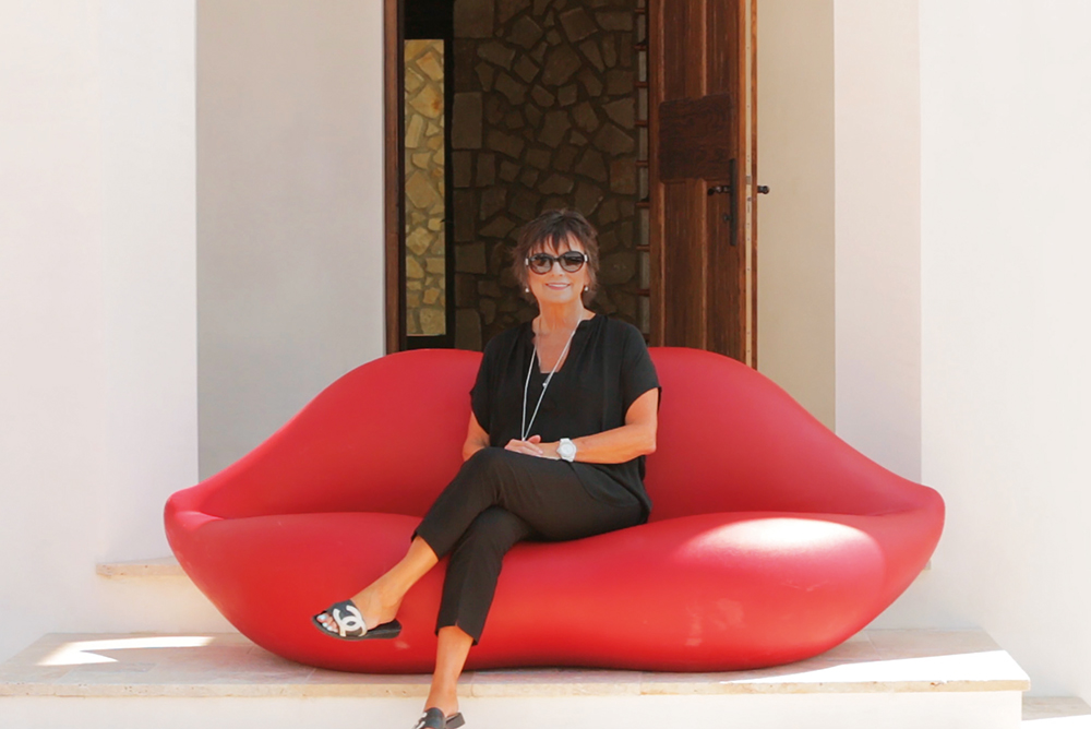 Linda Miller in front of one of her properties luxury real estate the smile of 30a lips sofa