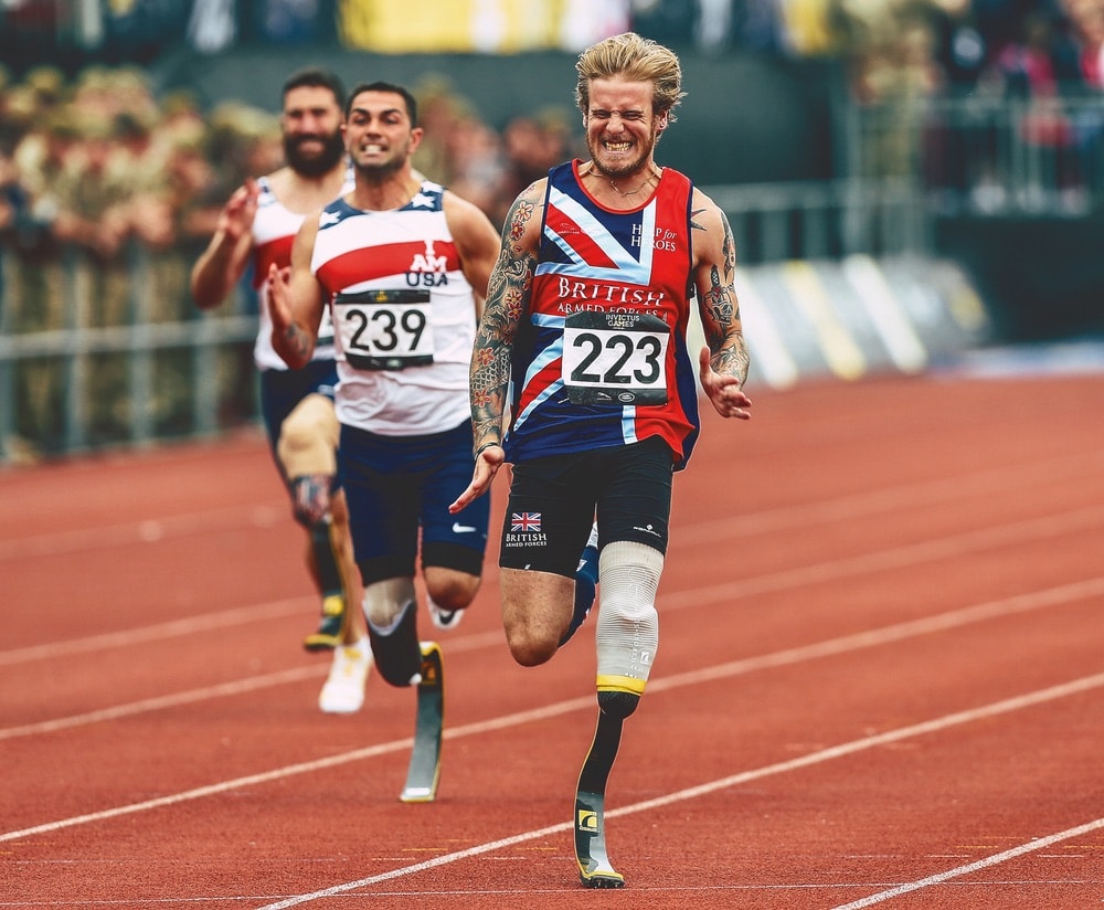 Runners compete in the men’s IT1 100-meter dash at the Invictus Games