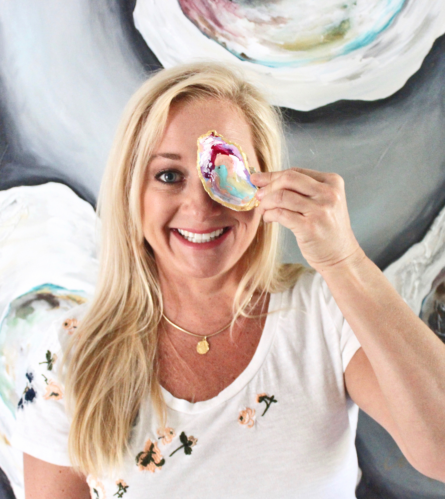 Artist Amy Fogg holding up a painted oyster