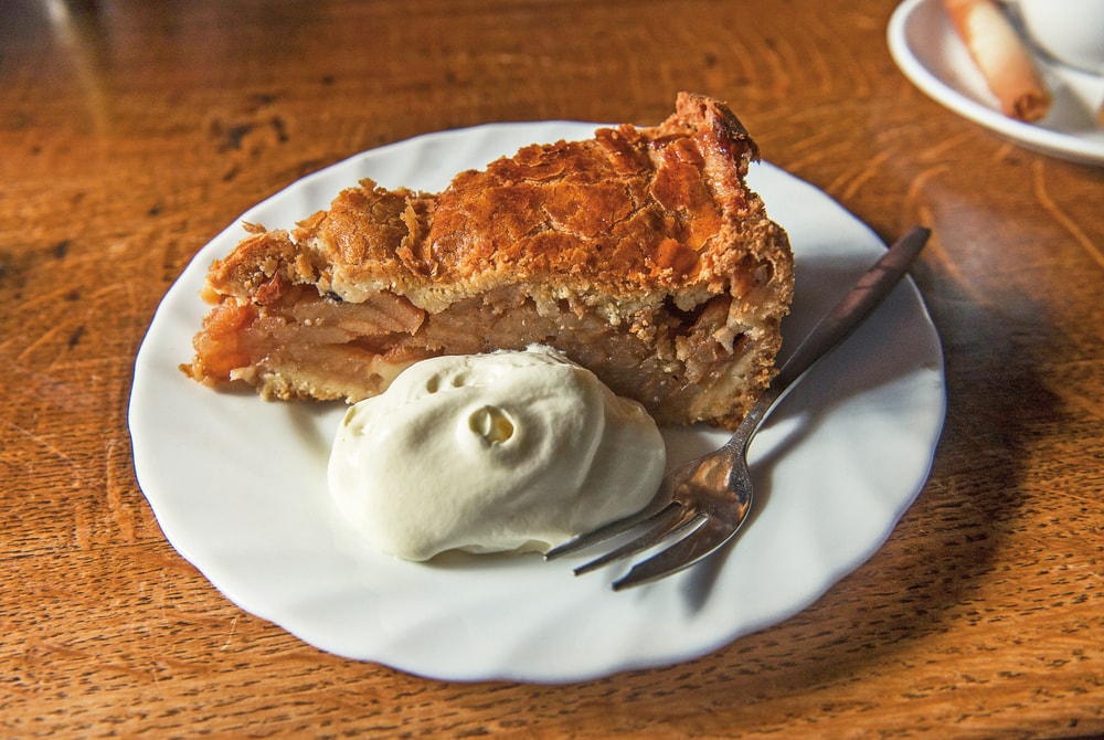 An Amsterdam favorite—the classic Dutch apple pie with a dollop of cream on the side Amsterdam Food VIE Magazine Destination Travel 2018