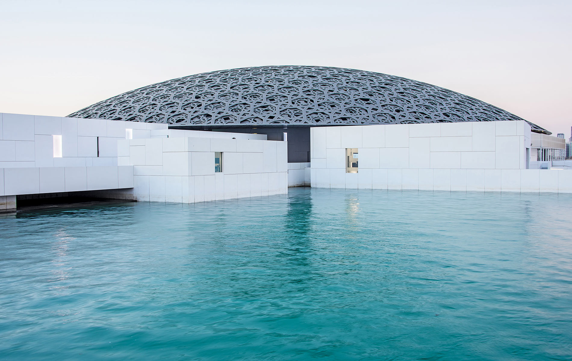 An exterior view of Louvre Abu Dhabi. The museum is completely surrounded by water and is only reachable by boat. | Photo by wangbin6007 / Shutterstock