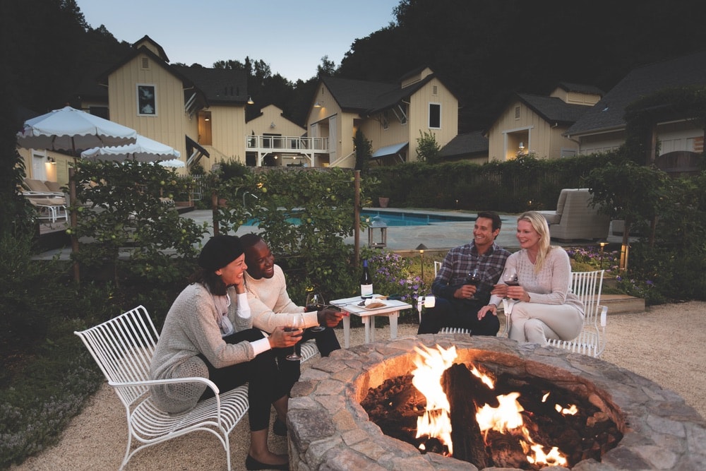 Sonoma County, California; Two couples enjoying the warm fire by the pool at Farmhouse Inn