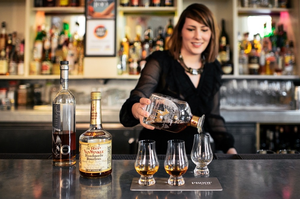 Mixologist at Proof on Main in pouring a flight of three bourbons for tasting; Louisville, Kentucky