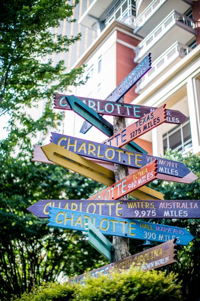 Directional sign with posts that each have a different location of Charlotte and the distance to get there