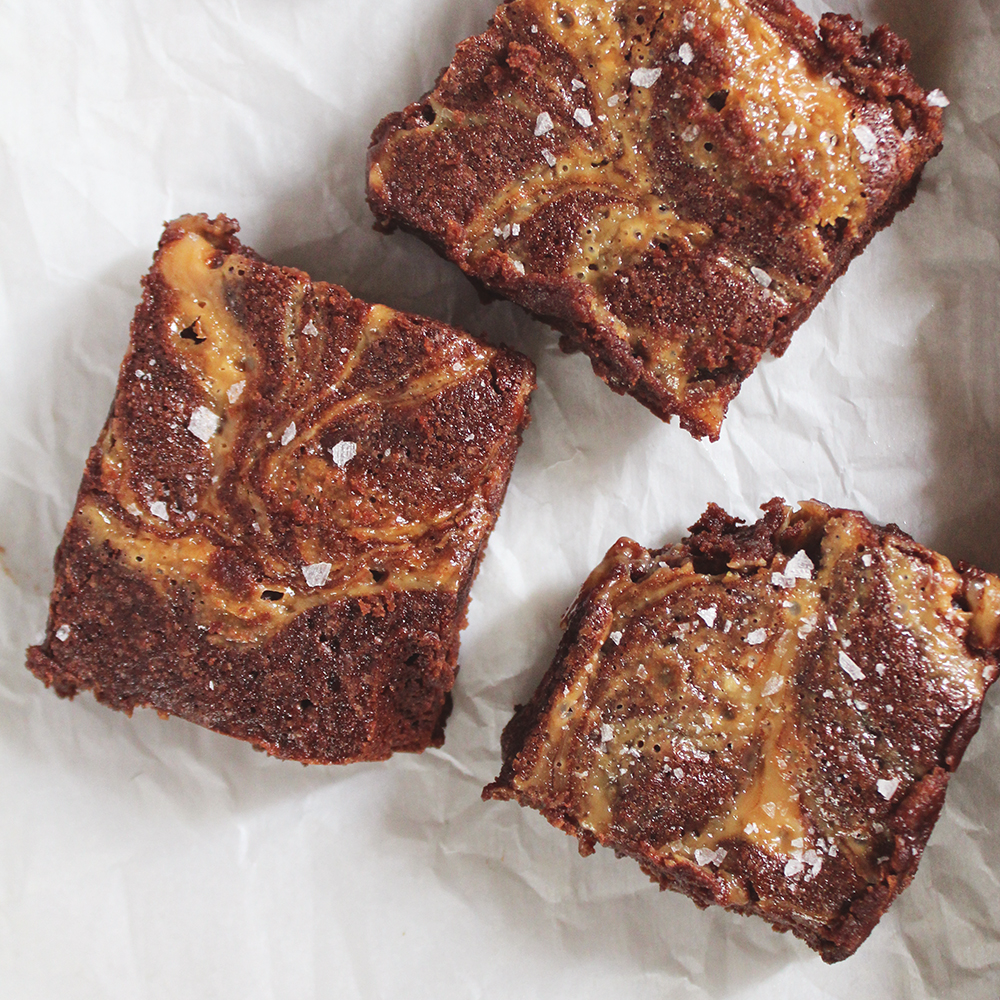 Three of Elisabeth's Salted Caramel Brownies cut into squares and sprinkled with sea salt