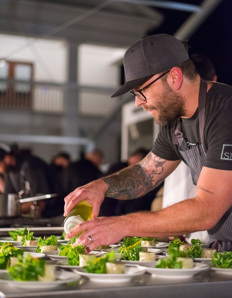 A chef preparing food at the Seeing Red Wine Festival.