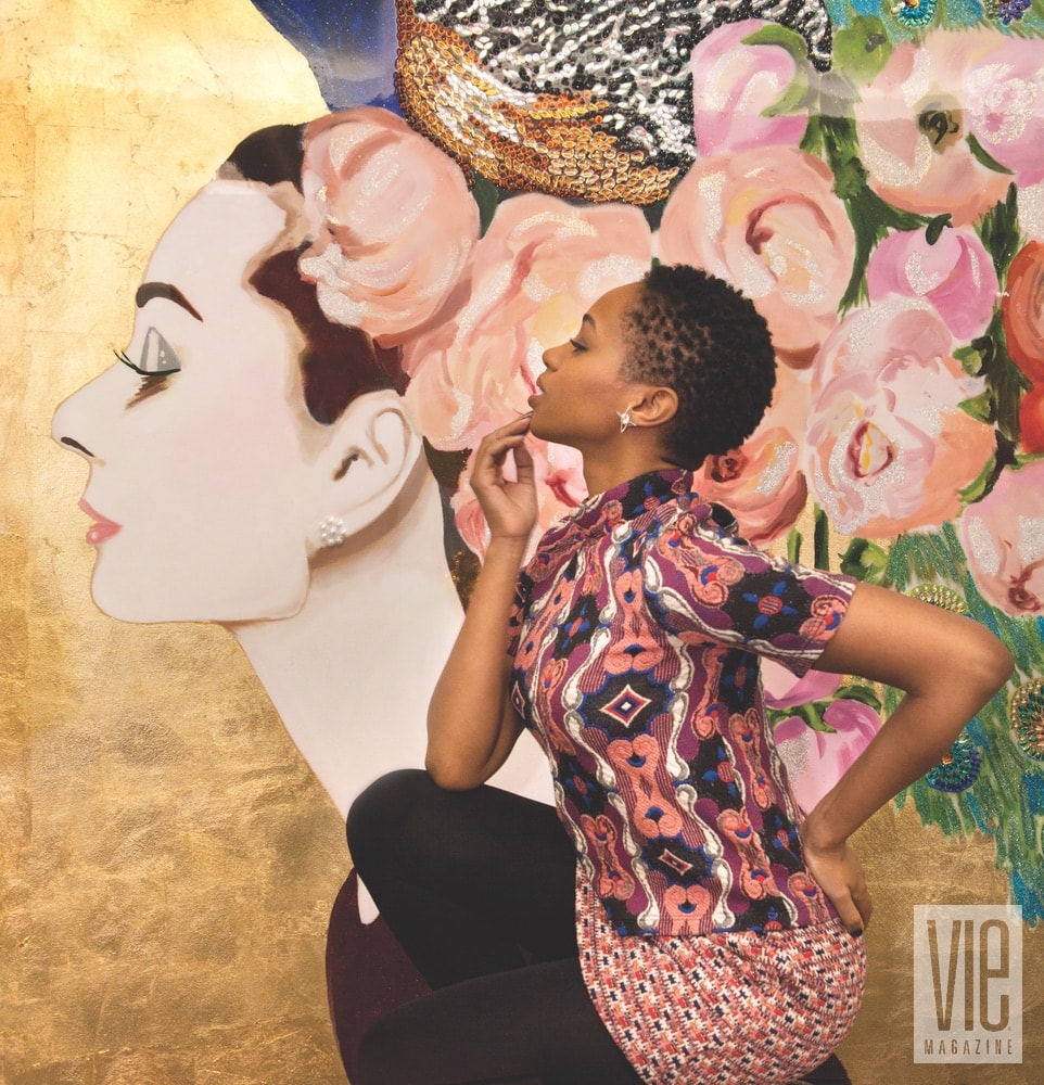 An attendee at the BG x Ashley Longshore opening event posing with a signature Audrey painting.