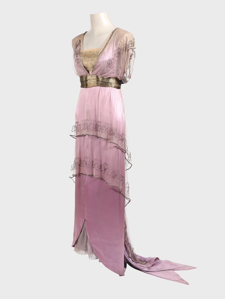 House of Worth formal dress made from two asymmetric tunics in chiffon, both longer at the back, with clover-leaf motifs embroidered in glass beads, covering a narrow silk satin underdress with a train of pointed streamers, gold lamé bodice, and belt.