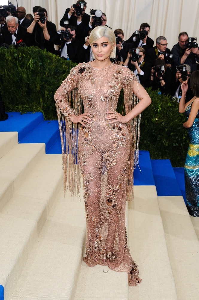 Kylie Jenner on the red carpet stairs the 2017 Metropolitan Museum of Art Costume Institute Gala in New York City sporting a platinum blonde wig.