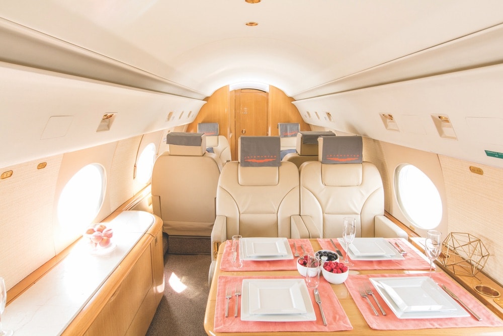 Inside of a JetSmarter jet with a table setting and fresh fruit.