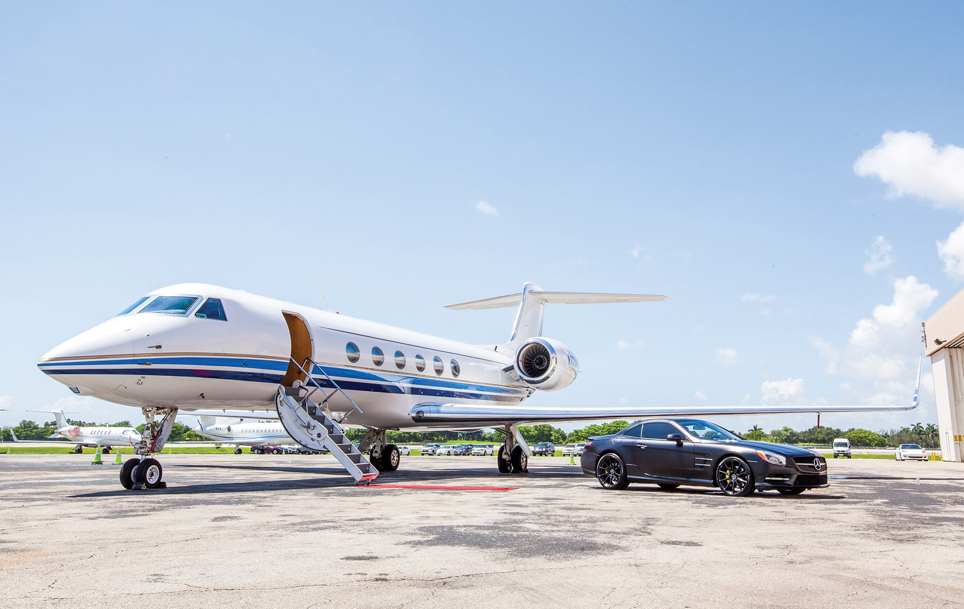 JetSmarter jet with a red carpet and a black car waiting at airport