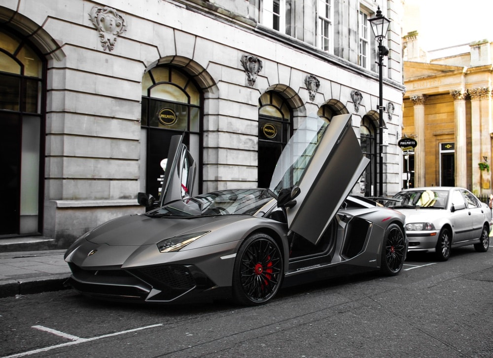 grey matte Lamborghini Aventador SV Roadster with both doors open is parked in Birmingham city centre. This effective hypercar is one of 500 cars of the model ever made