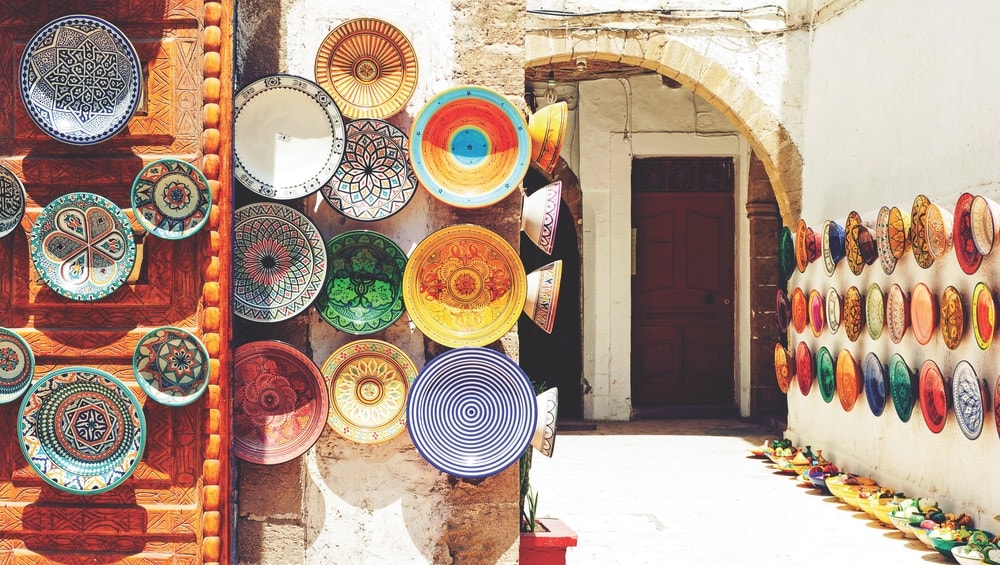 Colorful handcrafted plates line a market stall in Marrakech, Morocco.