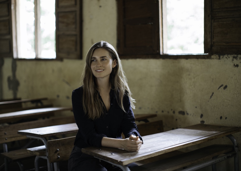 Lauren Bush Lauren sitting in a desk in a school