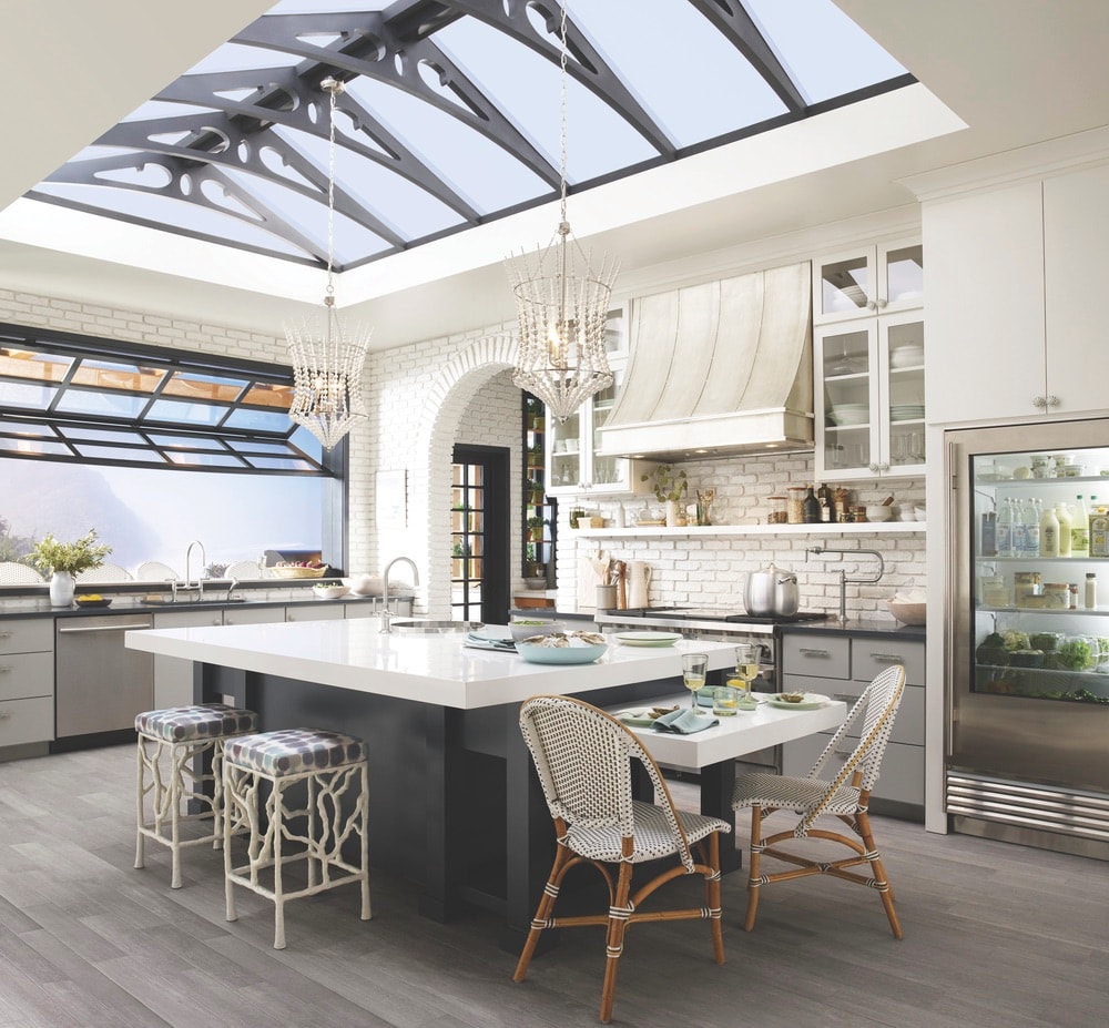 This open-concept greenhouse kitchen created by Cheryl Kees Clendenon in collaboration with Kohler, Silestone, and Benjamin Moore embodies utilitarian design with sink and faucet pairings that create a sense of flow and stability.
