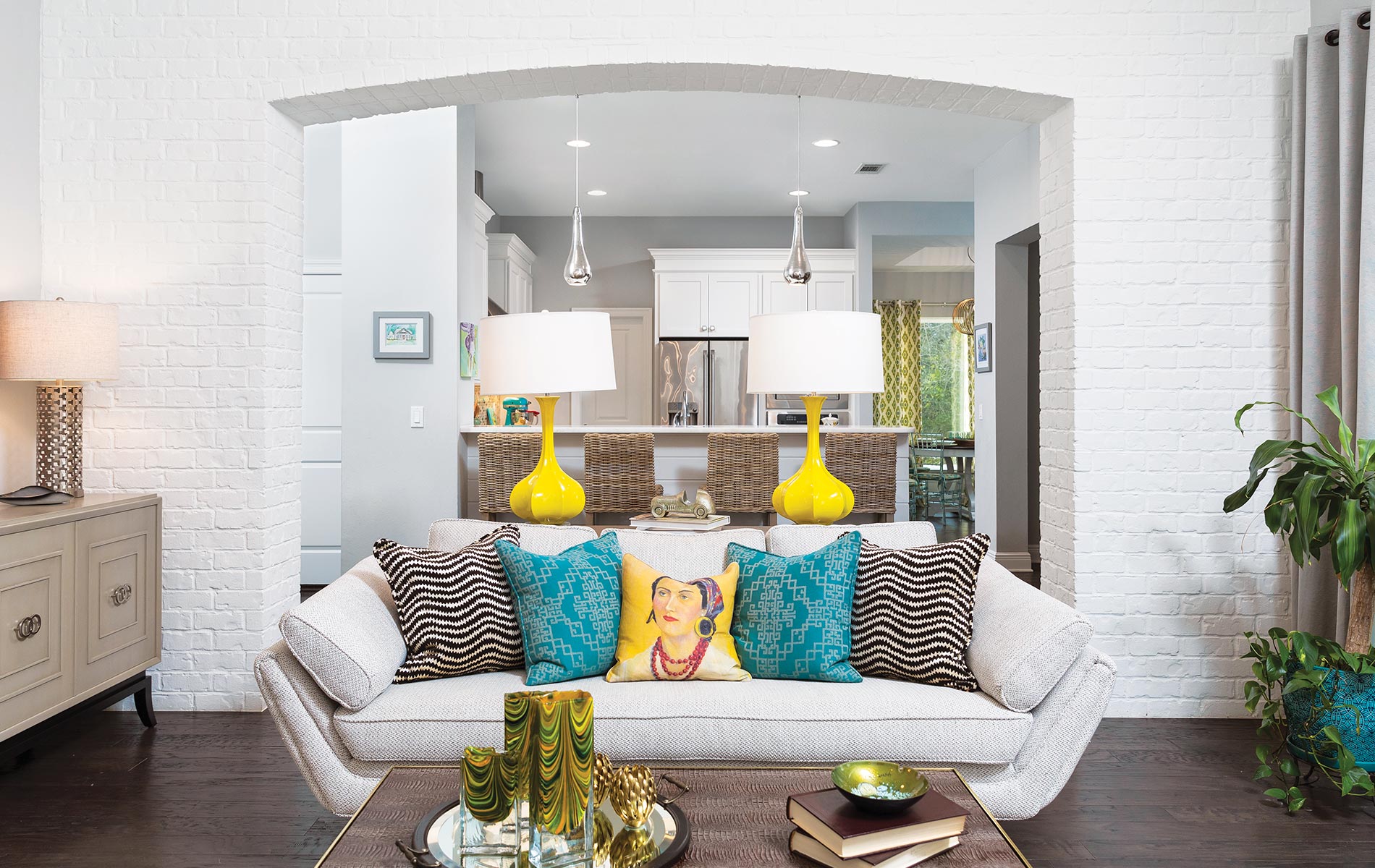 White painted brick is the perfect complement to colorful accents in this new construction home. Gorgeous lighting and proper placement of recessed can lights help create a bright and cheerful space with family in mind.