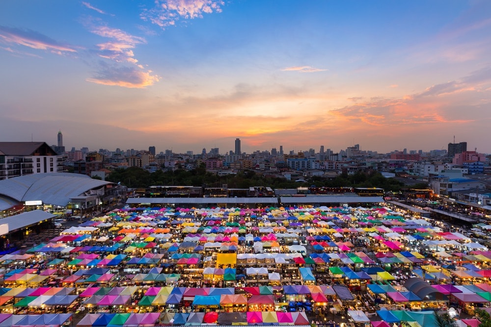 Aerial view, multiple colours flea market roof top with dramatic sky background after sunset